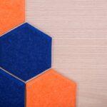 Hexagonale Schallabsorber aus Filz in Blau und Orange, ideal zur Schallreduzierung und als stilvolles Wanddesign.